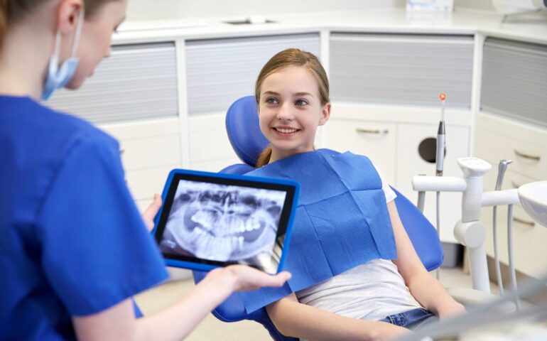 dentist with x-ray on tablet pc and patient girl